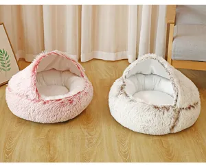 Detail view of two plush shell-shaped semi-enclosed warm pet beds on a wooden floor.