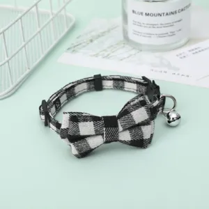 Close-up of black and white checkered pet collar with a bell and decorative bow detail