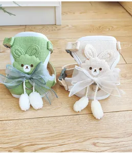 Detail of cute green and beige vest-style pet harnesses with bunny design and bows.