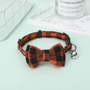 Detailed close-up view of the orange and black plaid pet collar with a bow and bell