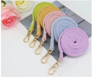 Detail view of five pastel-colored braided pet leashes with golden metal clasps