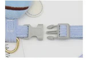 Close-up detail of the durable plastic buckle on a light blue corduroy pet harness