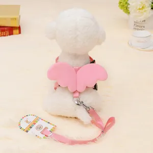 Rear view of a white dog mannequin wearing a pink angel wing pet harness and leash set