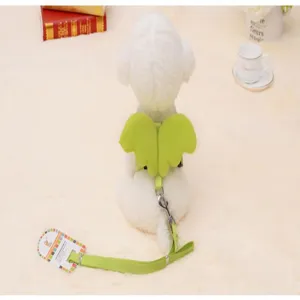 Rear detail view of a white dog wearing a lime green angel wing harness and leash set.