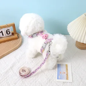 Close-up of pink patterned H-shaped adjustable pet harness and leash set on white dog