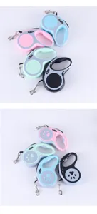 Various colorful retractable pet leashes with paw print design and ergonomic handle.