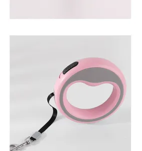 Détail d'une laisse rétractable rose circulaire avec poignée ergonomique