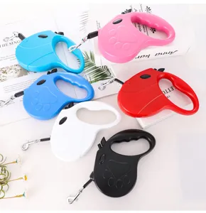 Detail view of retractable dog leashes in various colors arranged on books.