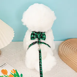Rear view of white dog wearing green plaid snowflake pet harness and leash set with bow