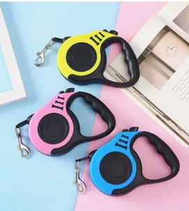 Trio of retractable dog leashes in yellow, pink, and blue on a colorful background