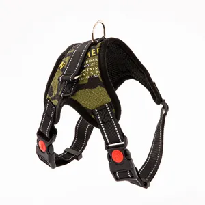 Macro detail of camouflage dog harness with reflective stitching and quick-release buckle.