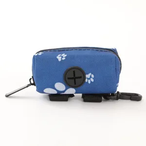 Portable blue pet poop bag dispenser with white paw prints and clip for outdoor use