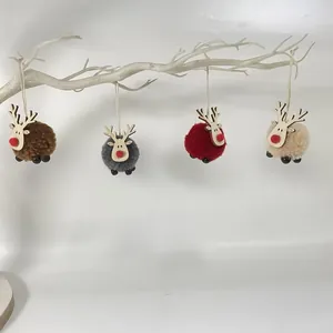 Juego de cuatro adornos de reno con pompones de colores colgados de una rama decorativa.