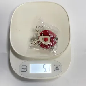 Detalle del adorno navideño de fieltro de reno que muestra un peso ligero de 5.1g en una báscula.