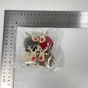 Set de 4 adornos navideños de renos de fieltro en embalaje con regla para escala