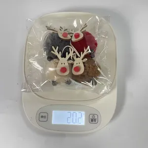 Medición de cuatro adornos navideños de renos de fieltro en balanza digital de 20,2 g