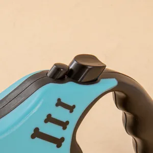 Close-up of blue automatic retractable dog leash with black bone pattern details