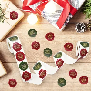 Festive red and green Merry Christmas wax seal style stickers shown on a decorative roll