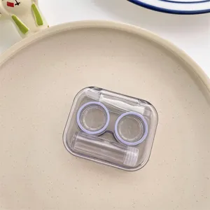 Close-up of clear portable contact lens case with tweezers and solution bottle