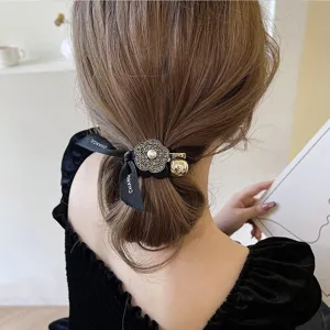 Élégant élastique à cheveux coréen rétro camélia strass avec ruban noir et perle chic.