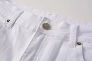Close-up detail of white denim jeans waistband and metal button, high street casual style.