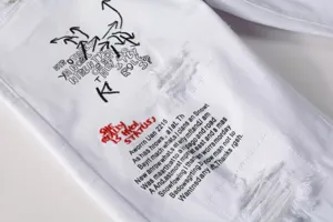 Men white distressed embroidered slim fit denim jeans detail view streetwear pants