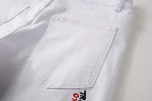 Close-up detail of mens white denim jeans back pocket with embroidered lettering.