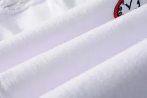 Detailed close-up view of white distressed stretch denim jeans with stylish embroidery for men.