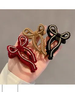 Dettaglio molletta per capelli con fiocco strass in velluto, elegante stile francese.