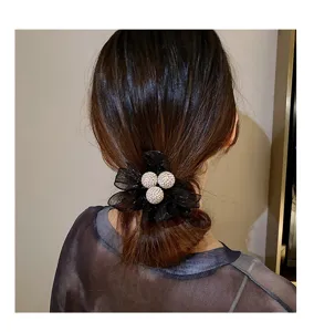 Gros plan détaillé d'un chouchou en maille noire élégant décoré de boules de strass.