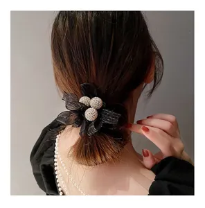 Vue de détail de l'élastique à cheveux en tulle noir et strass, boules scintillantes pour queue de cheval.