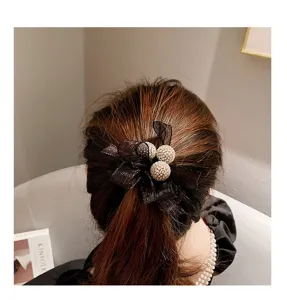 Vue détaillée de l'élastique à cheveux en maille noire avec sphères strassées élégantes.