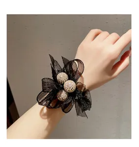 Vue de détail d'un chouchou à cheveux en tulle noir avec des boules en strass.