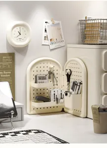 Cream white desktop pegboard organizer displaying stationery and home accessories