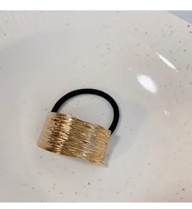 Detailopname van stijlvolle haarband met gouden metalen buis, elegante paardenstaart.