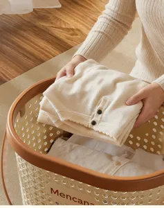 Detailed view of cream imitation rattan laundry basket with brown rim and handle