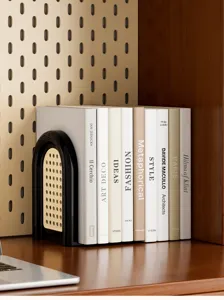 Elegante fermalibri nero con dettagli in rattan intrecciato su uno scaffale di legno