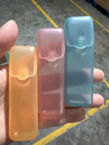 Vue de trois mini boîtes de rangement en plastique givré rose, bleu et orange à la main