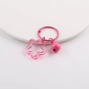 Nahaufnahme eines rosa Stern-Anhängers und Glocken-Schlüsselanhängers