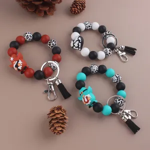 Silicone beaded wristlet keychain details featuring tassels and gnome charms for bags and keys.