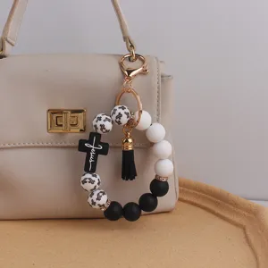 Silicone beaded bracelet keychain with cross print, black cross pendant and tassel.