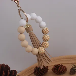 Silicone and wooden bead wristlet keychain with checkered pattern and chic leather tassel detail.