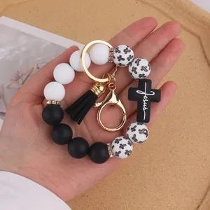Silicone bead wristlet keychain with cross pendant and black tassel, trendy style.