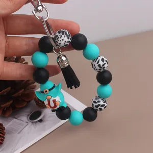 Silicone beaded wristlet keychain with tassel and cute gnome charm, bag accessory detail.