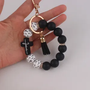 Silikon-Perlen-Armband-Schlüsselanhänger mit schwarzem Kreuz-Anhänger und Quaste.