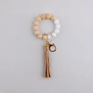 Detailed view of the silicone and wooden bead keychain bracelet with tassel and size mark.