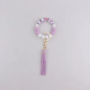 Silicone bead keychain bracelet with tassel, purple floral design charm accessory for keys and bags.