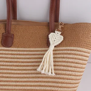 Handmade macrame heart keychain detail, white cotton rope tassel pendant with gold lobster clasp.