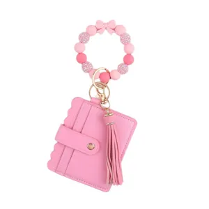 Llavero de pulsera de cuentas de silicona rosa con tarjetero de cuero y diseño de borla.