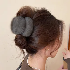 Gros plan d'une pince a cheveux en fausse fourrure pelucheuse avec texture foncee pour coiffure.